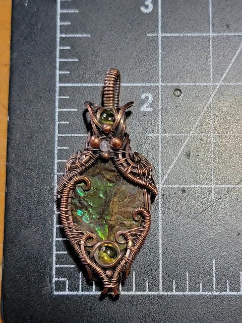 Ammolite w/ Peridot in Antiqued Copper w/ Peekaboo Crescent Moon in the Back Wrapped by Hand